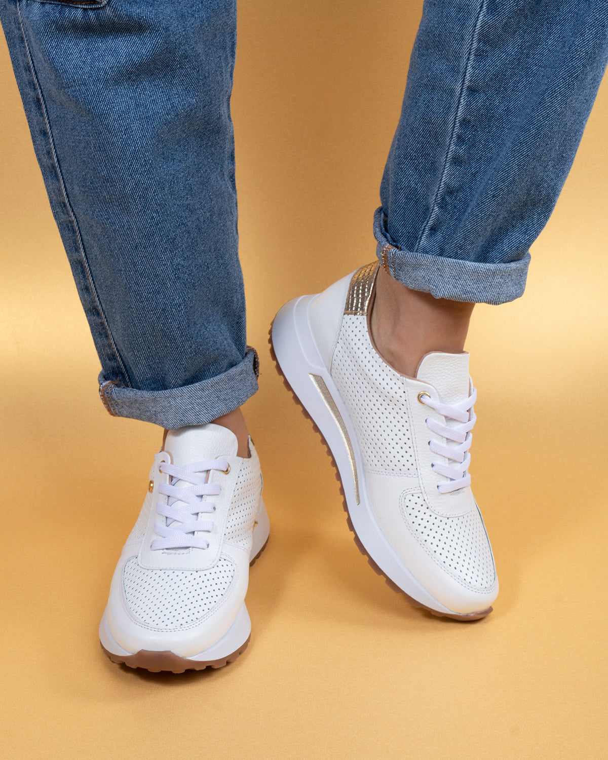 Tenis deportivos de cuero color blanco con perforaciones
