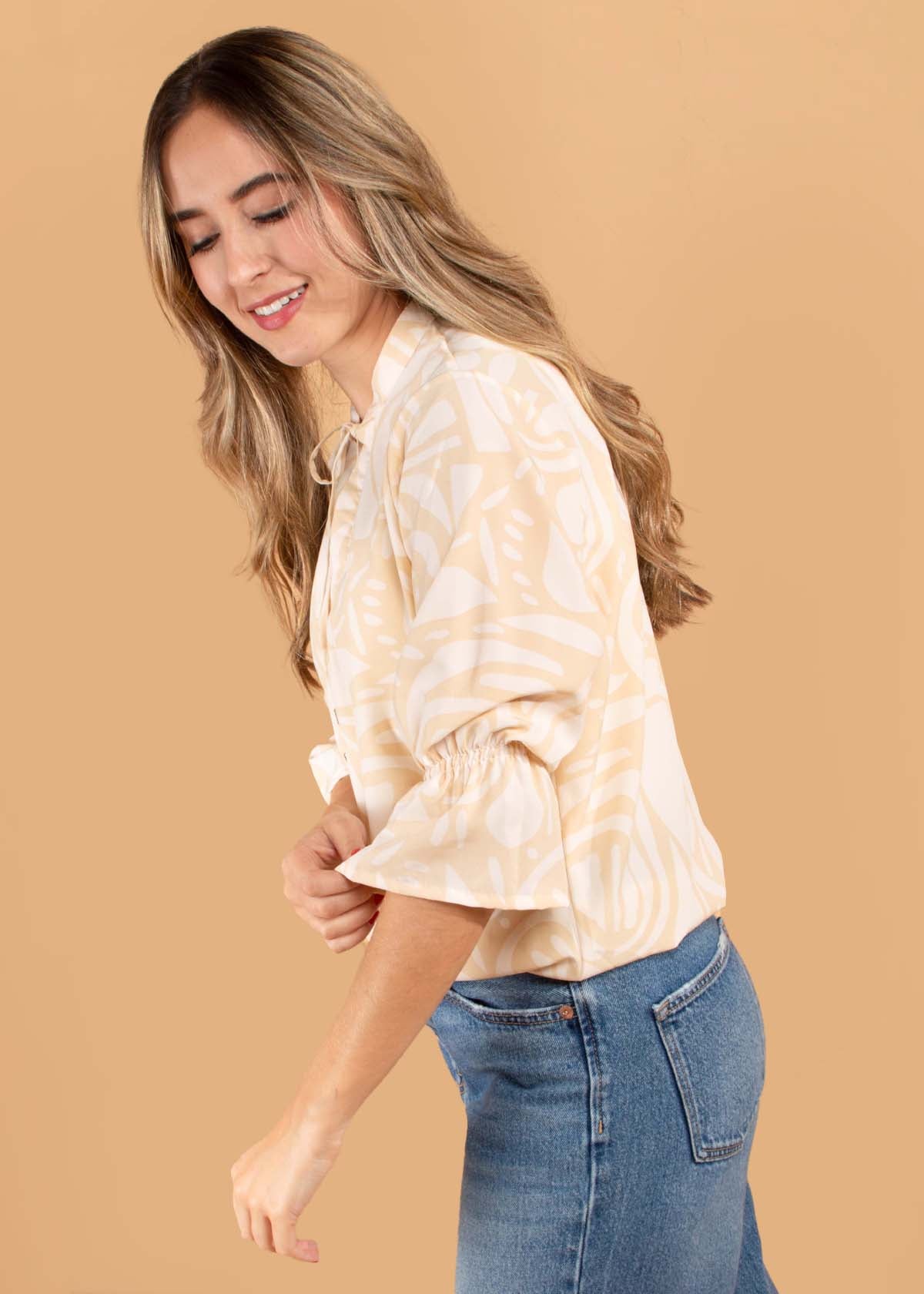 Blusa color marfil con estampado y moño ajustable en cuello 104498