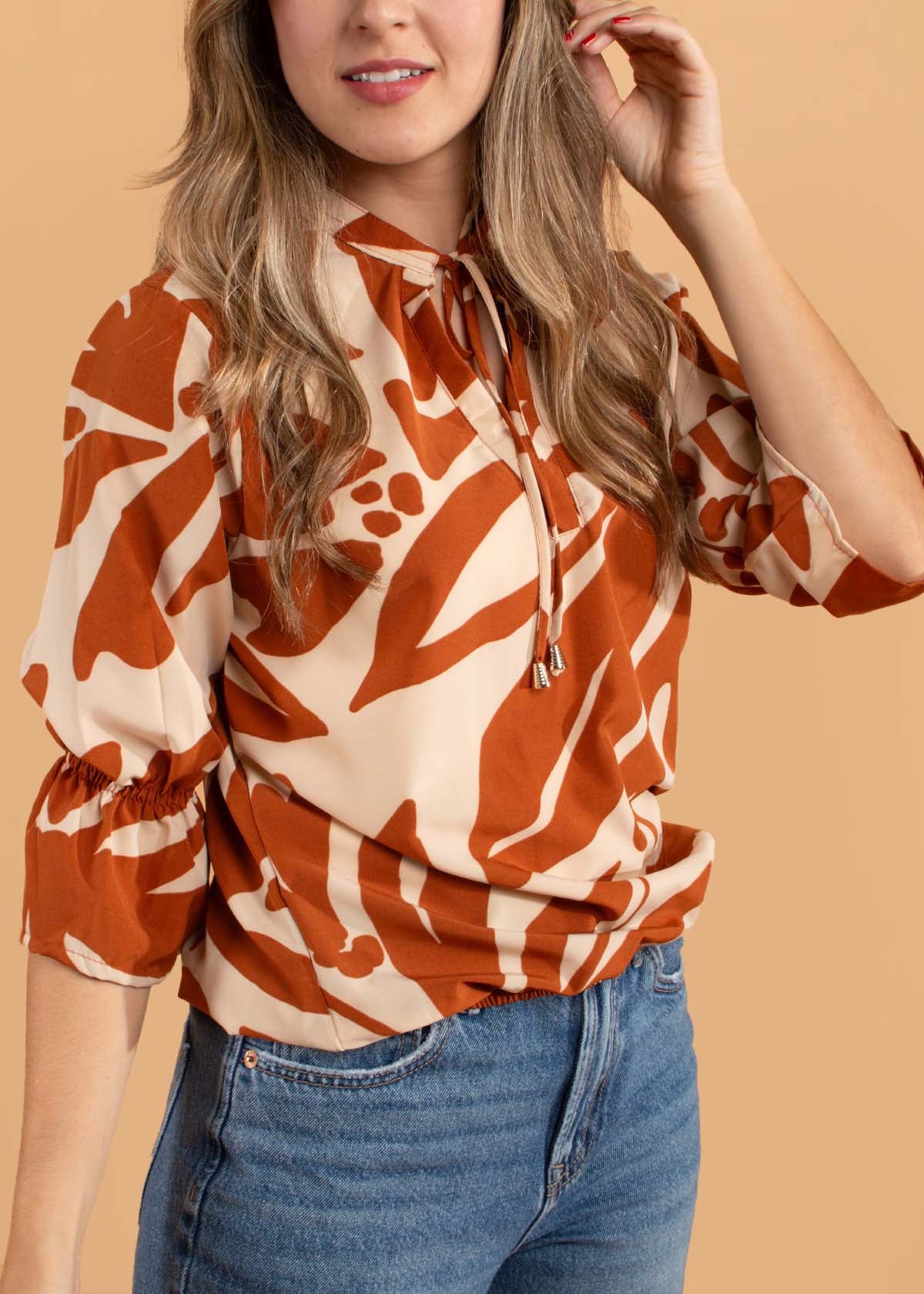 Blusa color terracota con estampado y moño ajustable en cuello 104498