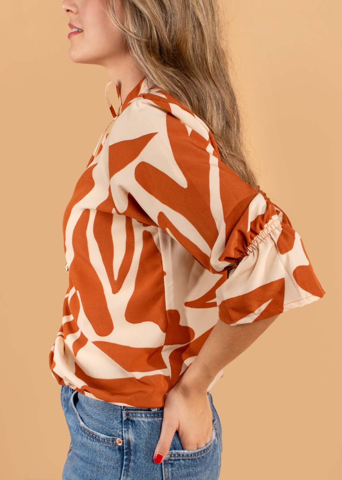 Blusa color terracota con estampado y moño ajustable en cuello 104498